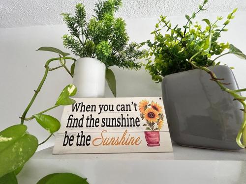 a sign sitting on a table next to a vase at St Paul’s Bay central apartment in Qawra in St Paul's Bay