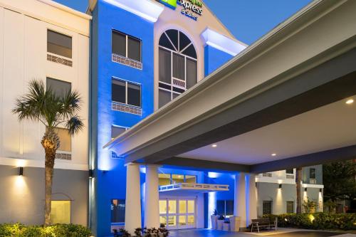 a blue building with a palm tree in front of it at Holiday Inn Express St. Petersburg North / I-275 by IHG in St. Petersburg
