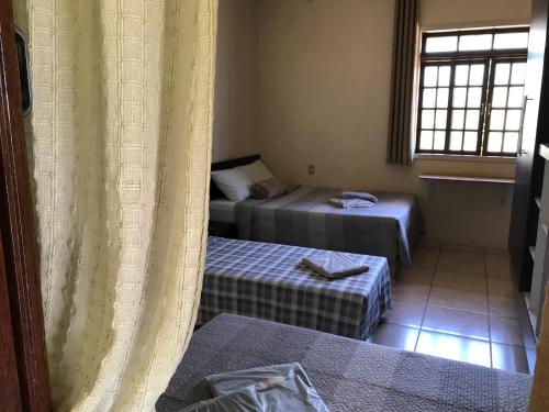 a room with two beds and a window at Pousada dos Azevedo in Cláudio