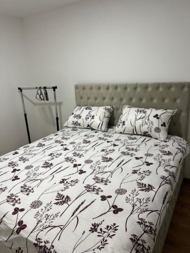 a bed with a black and white comforter and pillows at Stan na dan Ana in Prozor