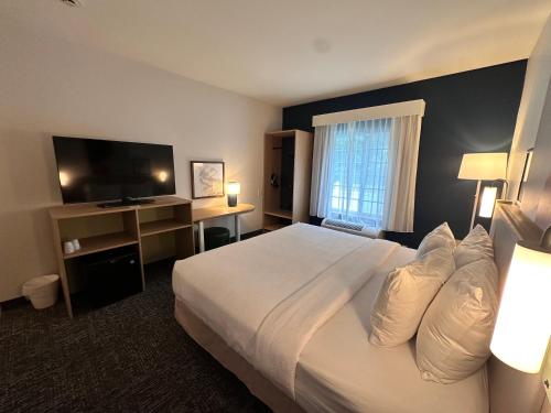 a hotel room with a bed and a television at Spark by Hilton Guilford in Guilford
