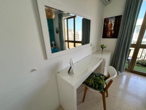 a bathroom with a white desk and a mirror at St Paul’s Bay central apartment in Qawra in St Paul's Bay