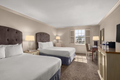 a hotel room with two beds and a television at Dauphine Orleans Hotel in New Orleans