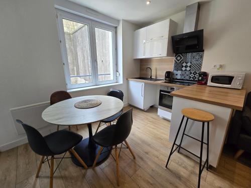 une petite cuisine avec une table et des chaises dans une pièce dans l'établissement Appartement cosy au cœur de Recouvrance, à Brest