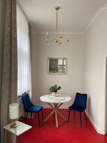 a dining room with a table and two blue chairs at Pension - Kavaliershaus Krumke - Schlüsseltresor - Kein TV in Krumke