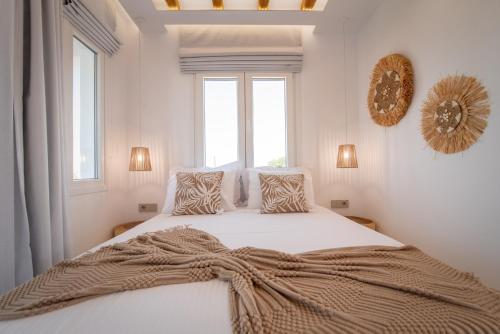 a white bedroom with a bed with a blanket on it at Vino luxury suites 2 in Agia Anna Naxos