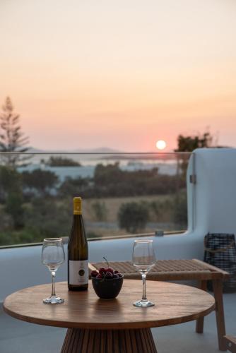 a bottle of wine and two glasses on a table at Vino luxury suites 2 in Agia Anna Naxos
