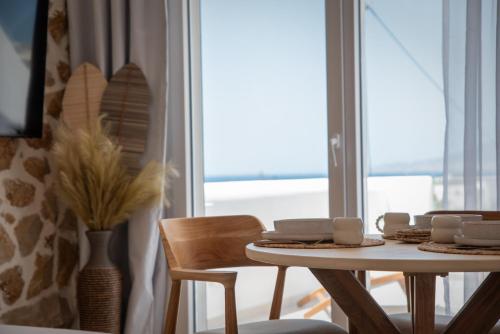 a dining room with a table and chairs and a window at Vino luxury suites 2 in Agia Anna Naxos