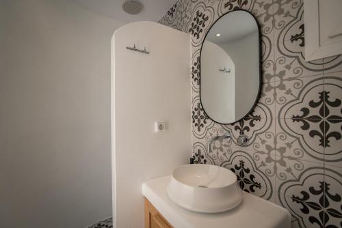 a bathroom with a sink and a mirror on a wall at Vino luxury suites 2 in Agia Anna Naxos
