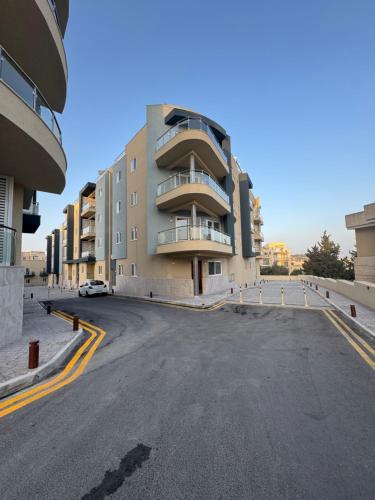 an empty parking lot in front of a building at Varka Holiday Apartment - Modern Family Friendly and Accessible for All in Marsaxlokk