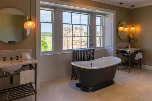 a bathroom with a large tub and a sink at Bailiffgate Hotel in Alnwick