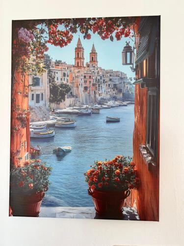 a view of a river from a window with flowers at St Paul’s Bay central apartment in Qawra in St Paul's Bay