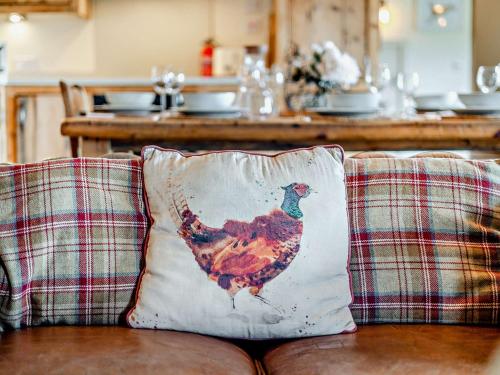 a rooster pillow sitting on the back of a couch at 4 Bed in Cemaes 90258 in Llanfechell
