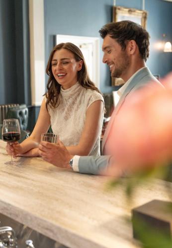 a man and a woman sitting at a bar with wine glasses at Bailiffgate Hotel in Alnwick