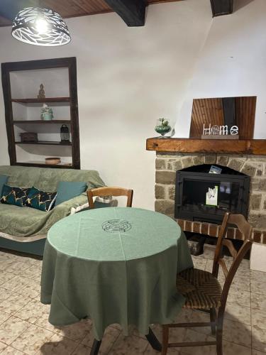 un salon avec une table et une cheminée dans l'établissement Plénitude, à Moulinet