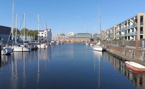 a group of boats docked in a river with buildings at Appartment am Yachthafen in Bremerhaven