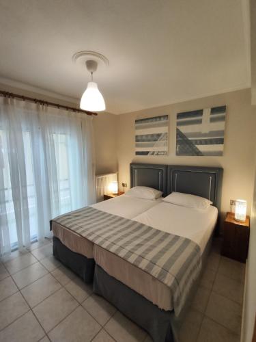 a bedroom with a large bed with a striped blanket at SOLMAR HOUSE in Flogita