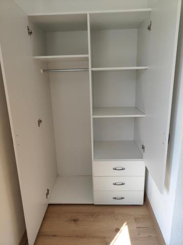 an empty closet with white shelves and a wooden floor at Ferienwohnung Landliebe, nahe Jennersdorf und Therme in Windisch Minihof