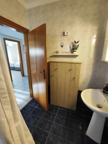 a bathroom with a sink and a toilet and a door at SOLMAR HOUSE in Flogita