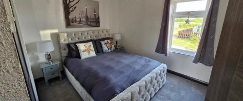 a bedroom with a bed and a window at Waterside Lodge - Dog Friendly Sutton on Sea in Sutton on Sea