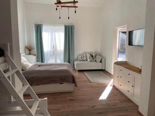 a bedroom with a bed and a tv and a couch at Ferienwohnung Wulkatal 