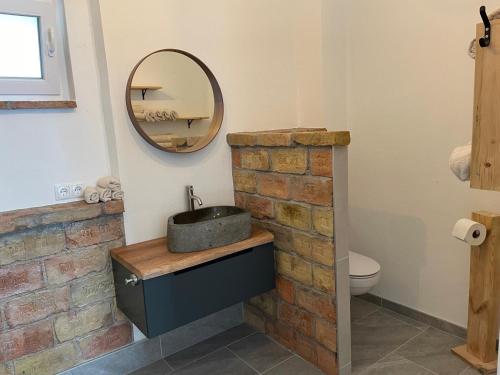 a bathroom with a stone sink and a mirror at Ferienwohnung Wulkatal 