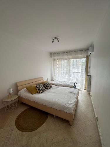 une chambre avec un grand lit avec une fenêtre dans l'établissement Le président 100 m de la plage, à Antibes