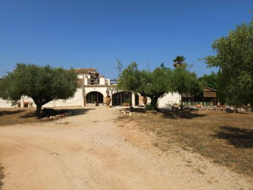 a house with trees in front of a dirt road at Resort Carpe Diem El Perelló in Perelló