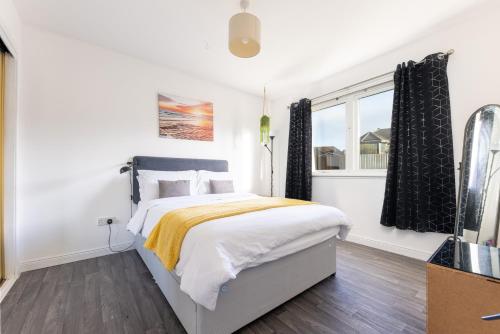 a white bedroom with a bed and a window at Lochnomore - A Luxury Home With Magnificent Views in Nairn