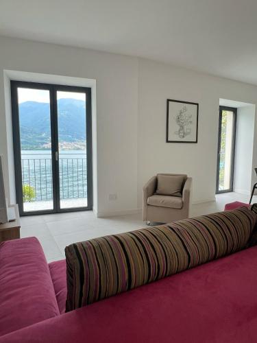 a living room with a large bed and a chair at Il Porticciolo in Lezzeno