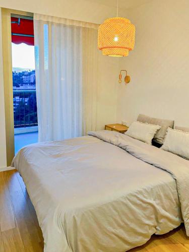 une chambre avec un grand lit et une fenêtre dans l'établissement Constellations - Wifi, AC, Piscine, 4pers, à Nice