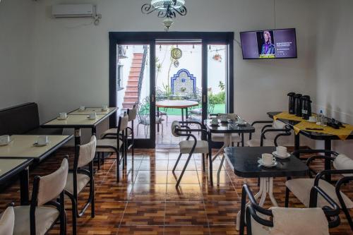 a dining room with tables and chairs and a television at Hostel Pituco - En el corazón de la ciudad in Mendoza