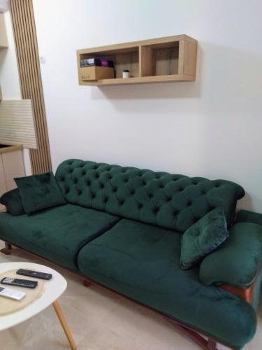 a green couch in a living room with a table at Apartmant Novaković in Vrnjačka Banja