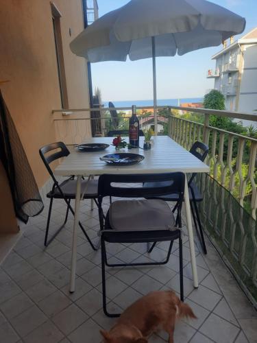 a table and chairs and a dog on a balcony at CadiLina in Ceriale
