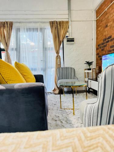 a living room with two couches and a tv at Luu's luxurious in Johannesburg