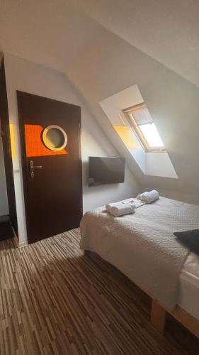 a bedroom with a bed and a skylight at Norwida 28 - 300m od plaży in Olecko