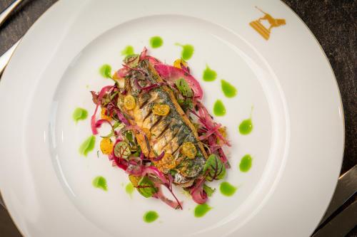 a white plate with a salad with fish on it at Bailiffgate Hotel in Alnwick