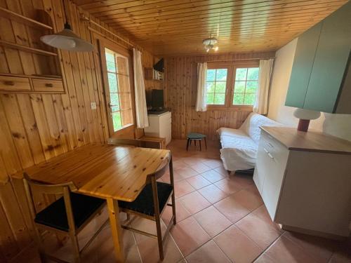 un salon avec une table en bois et un canapé dans l'établissement Appartement avec jardin au coeur de la nature, à Zinal
