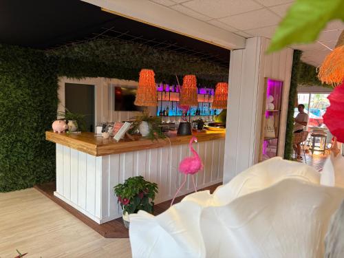 a bar with a pink flamingo in a restaurant at Cit'Hotel des 2 Golfs in Port Leucate