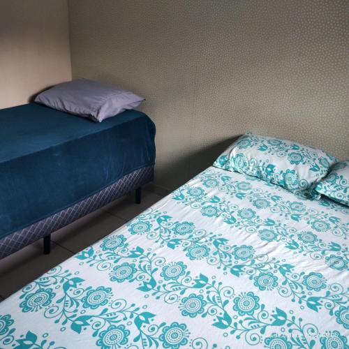 a bedroom with two beds with blue and white sheets at Casa das Embaúbas 03 in São José