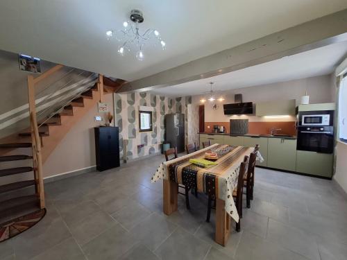 une cuisine et une salle à manger avec une table et un escalier dans l'établissement Rodoudou, à Châteauvieux
