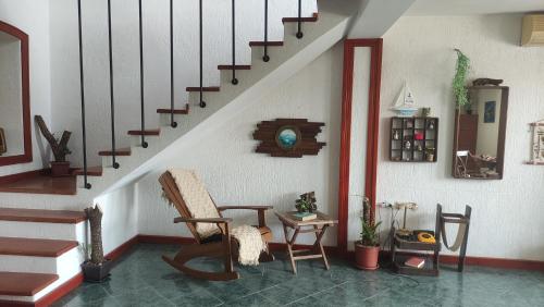 a room with a staircase with a chair and a table at Woodpecker Backpacker Hostel in Herceg-Novi