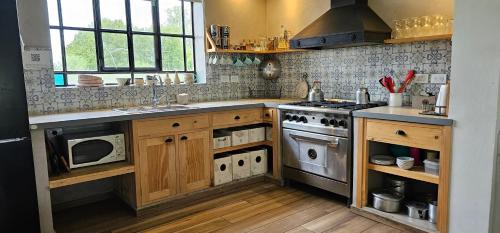 a kitchen with a sink and a stove top oven at Casa de campo Don Juan in Duggan