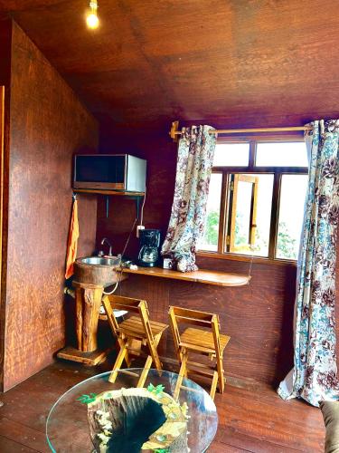 a room with two chairs and a table and a microwave at Trini Treehouse By GEstores in Huasca de Ocampo