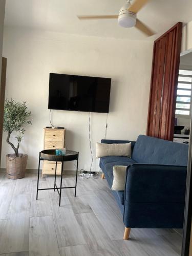 a living room with a blue couch and a table at Escale Papillons Peyi Lodge in Le Vauclin