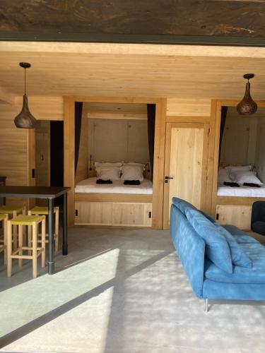 - un salon avec un canapé bleu et 2 lits dans l'établissement Lechappee des causses, à Mostuéjouls