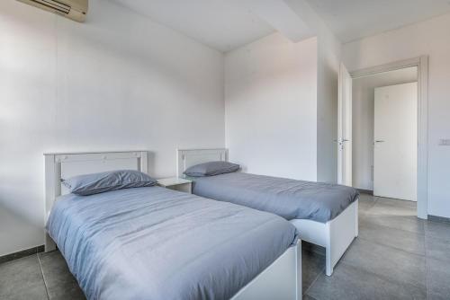 two beds sitting next to each other in a bedroom at three-room apartment with terrace Free Wifi in Bareggio