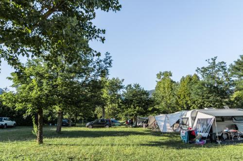un groupe de tentes dans un champ arboré dans l'établissement Camping Onlycamp Les Tuillères, à Vercheny