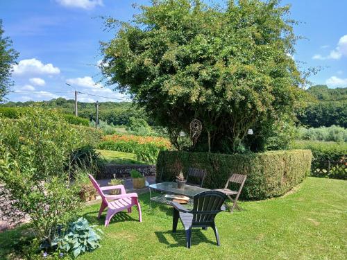 a group of chairs and a table in a garden at Le Clair Matin in Tortefontaine