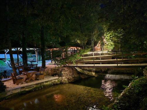 a bridge over a river in a park at night at Etno selo BISTROVO in Vitez